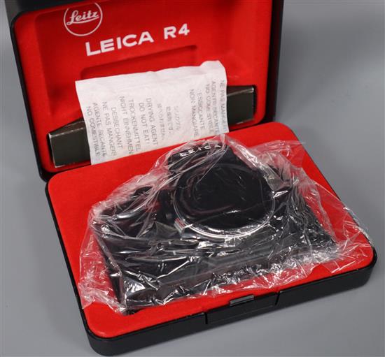 A Leitz black Leica R4 body in presentation box, a Zeiss Ikon Super Ikonta folding bellows camera and sundry accessories